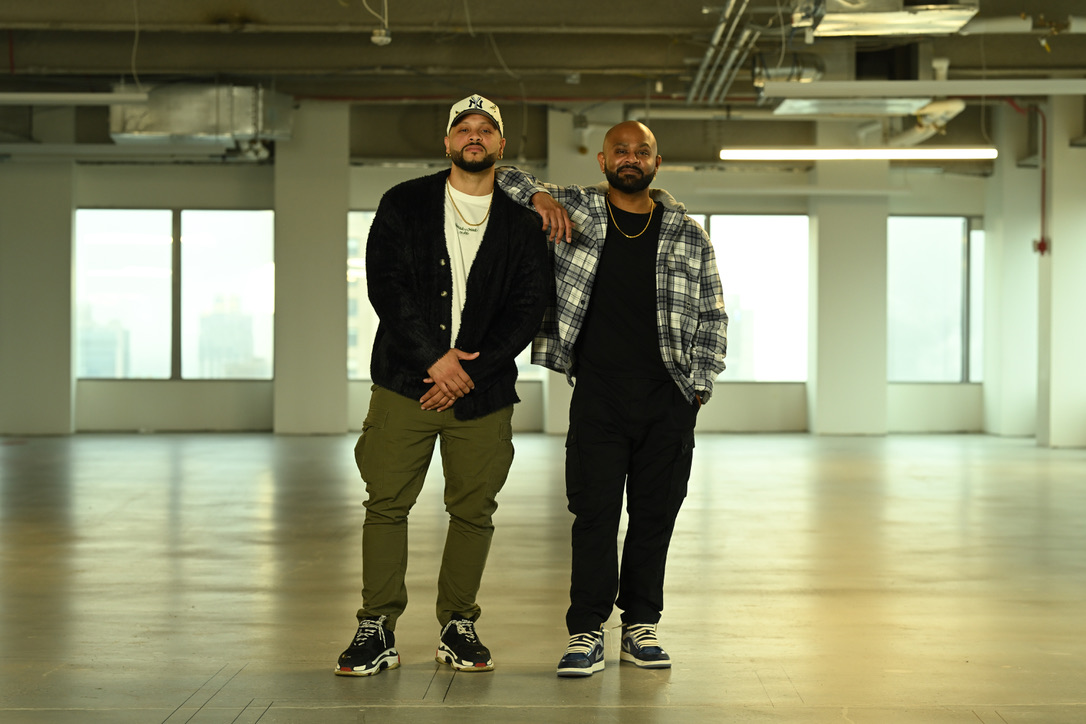 Two founders standing together in an empty office space